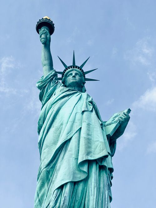 Free Iconic Statue of Liberty with a clear blue sky backdrop, symbolizing freedom and democracy. Stock Photo