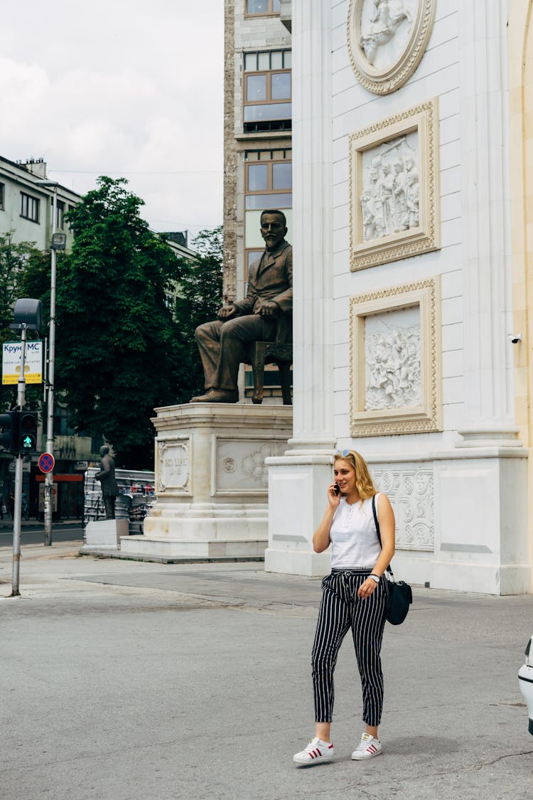 Woman Talking On The Phone Crossing The Street