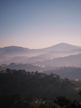 Serene misty mountain view bathed in soft morning light, ideal for nature lovers.