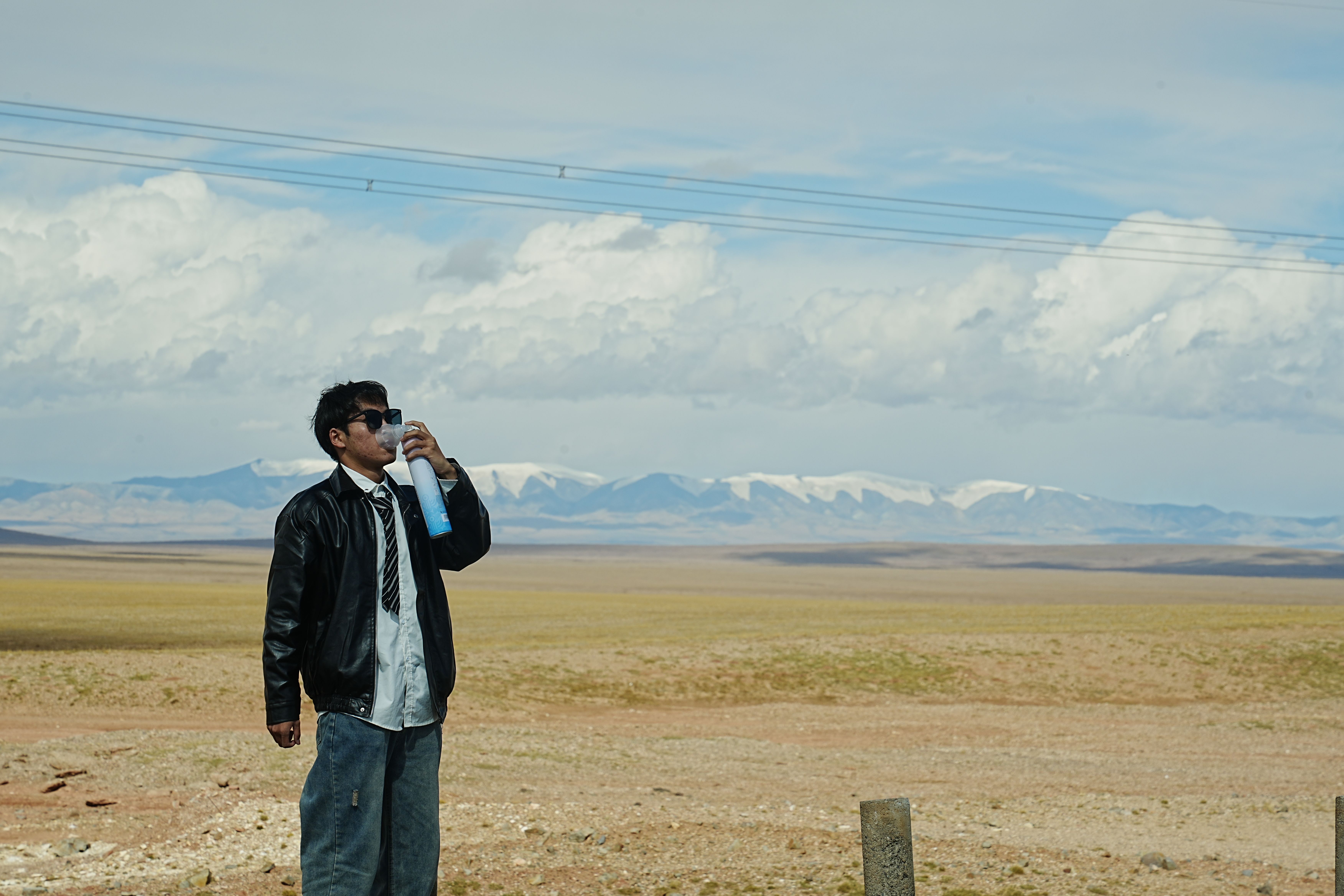 A traveler staying hydrated by drinking water in Bahrain, emphasizing sun safety.