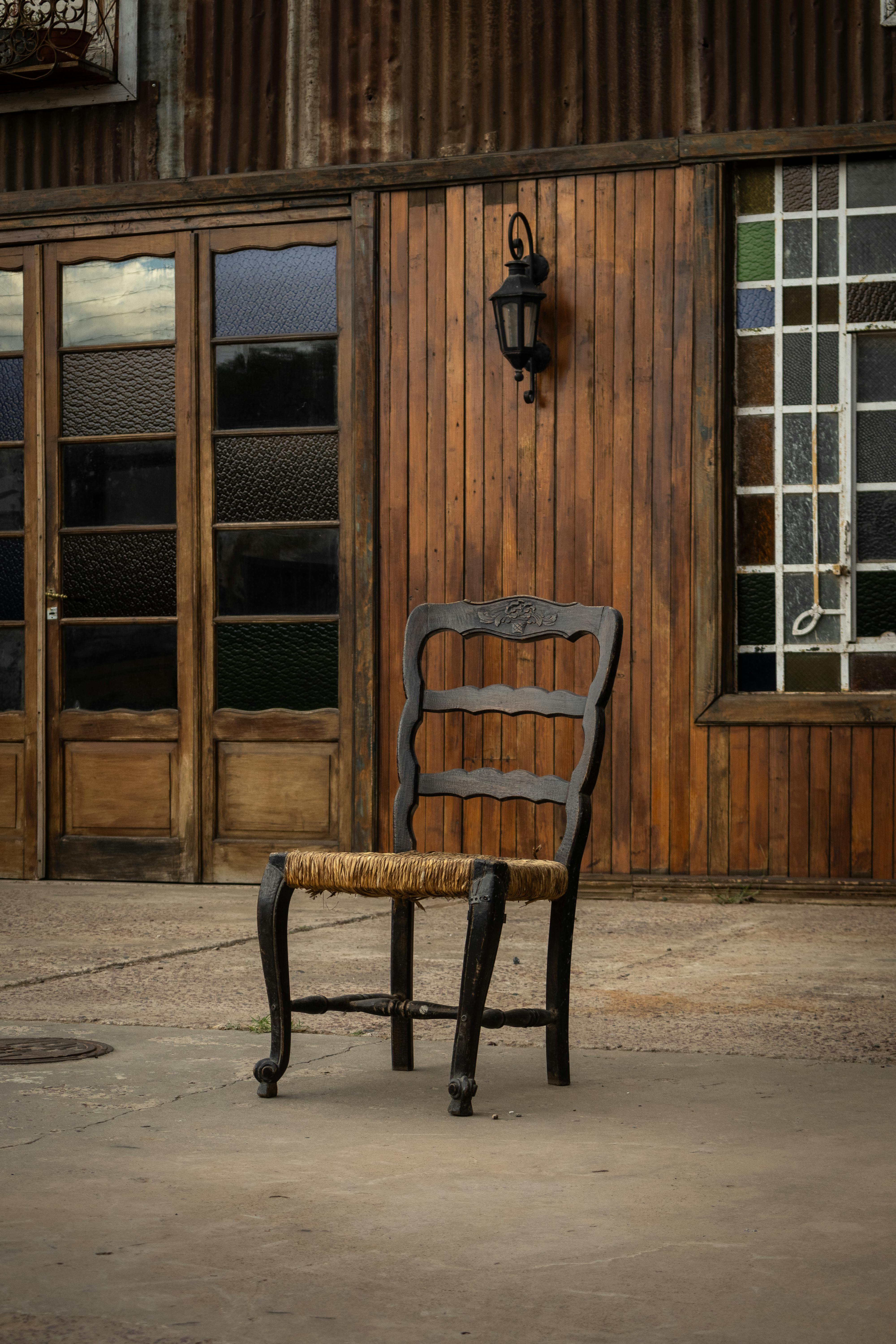 rustic wooden chair outdoors against vintage wall