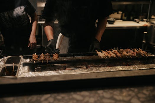 A chef grilling meat skewers in a dimly lit kitchen, creating an authentic culinary atmosphere.