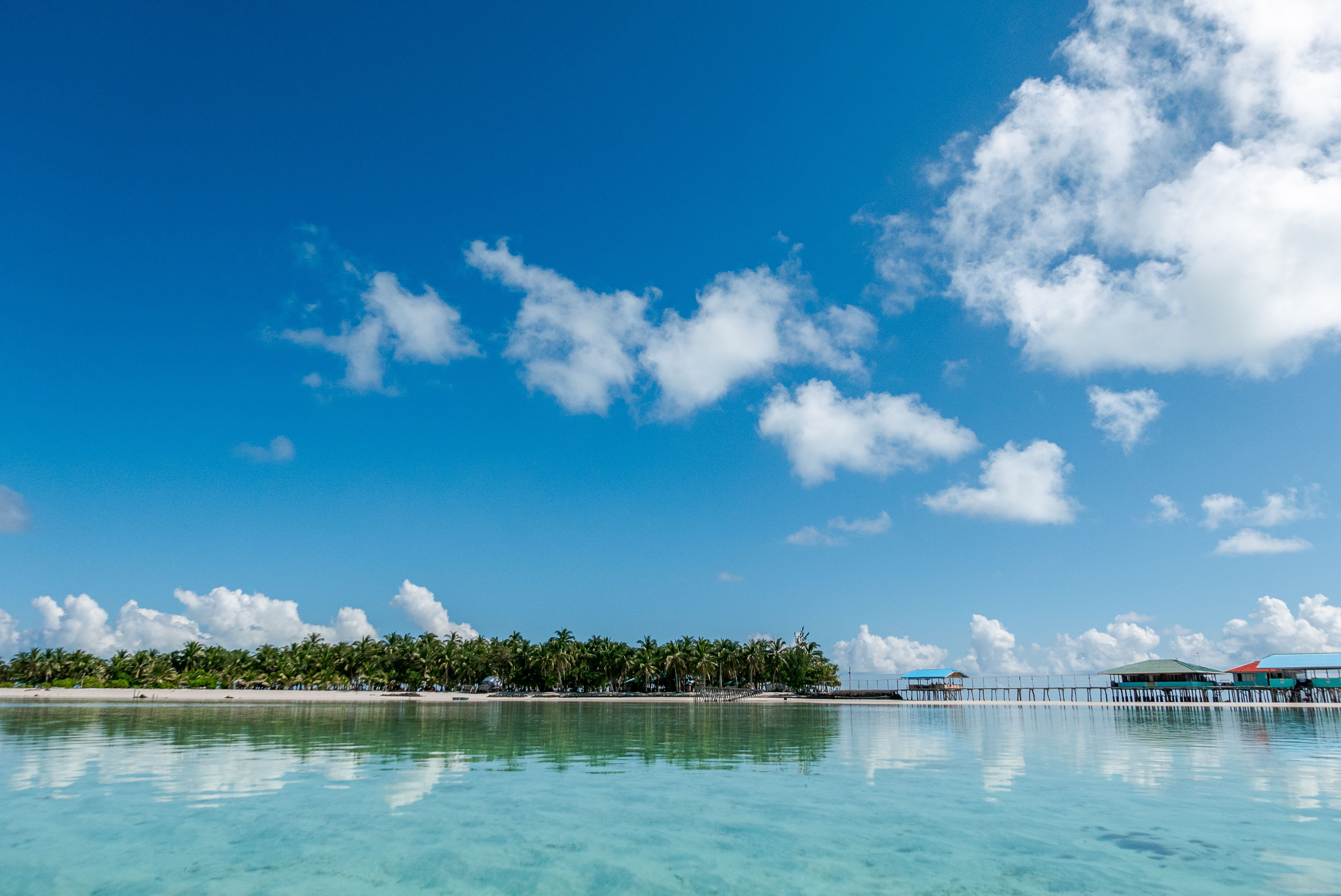 Superbe vue aérienne d'une île tropicale aux eaux bleues claires et au ciel vibrant.