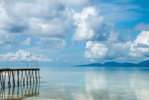 Free Stunning view of a clear blue sea and sky from a wooden pier, perfect for travel inspiration. Stock Photo