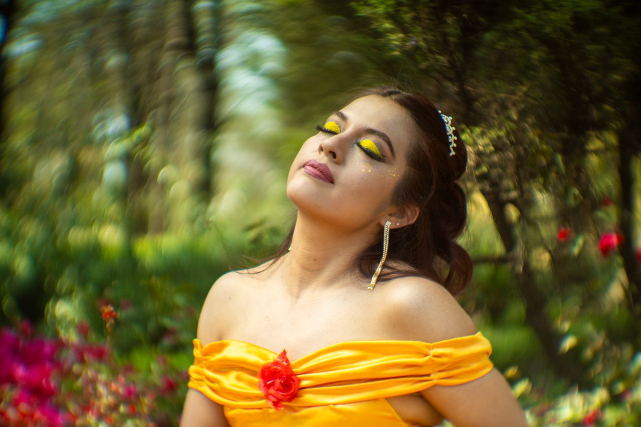 a woman in a vibrant yellow dress embraces nature in an outdoor settin