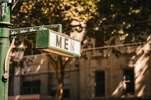 A nostalgic men's restroom sign in downtown Melbourne, captured with warm tones.