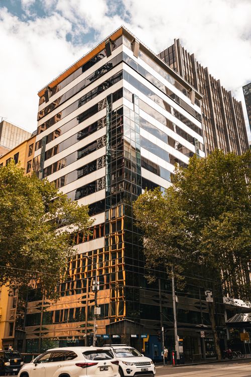Free A striking modern office building in Melbourne's CBD, captured in daylight with city street activity. Stock Photo