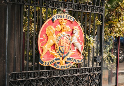 Colorful Royal Mint Victoria emblem on gate highlights Melbourne's heritage.