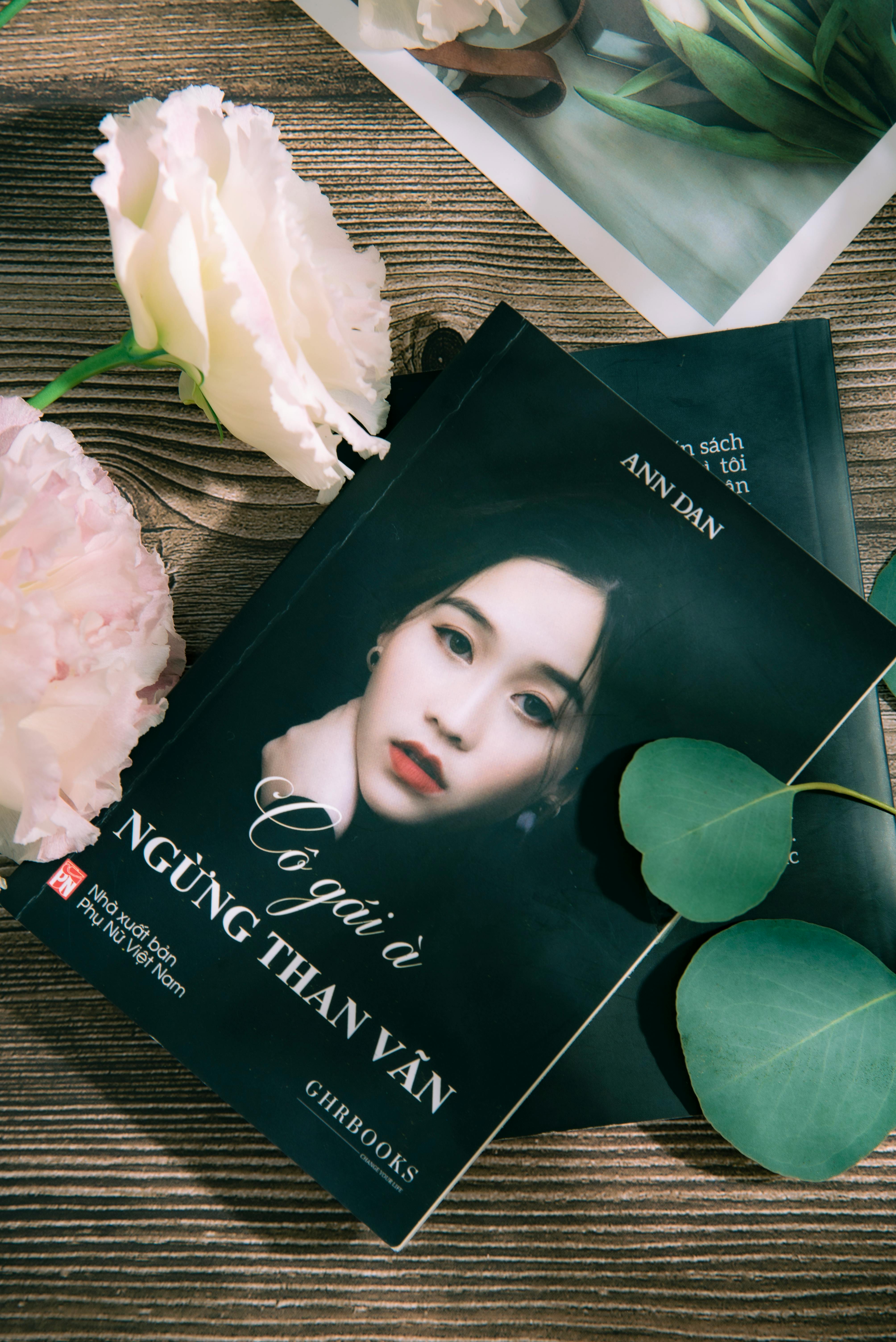 Photograph of a book featuring a woman's portrait surrounded by flowers and leaves.