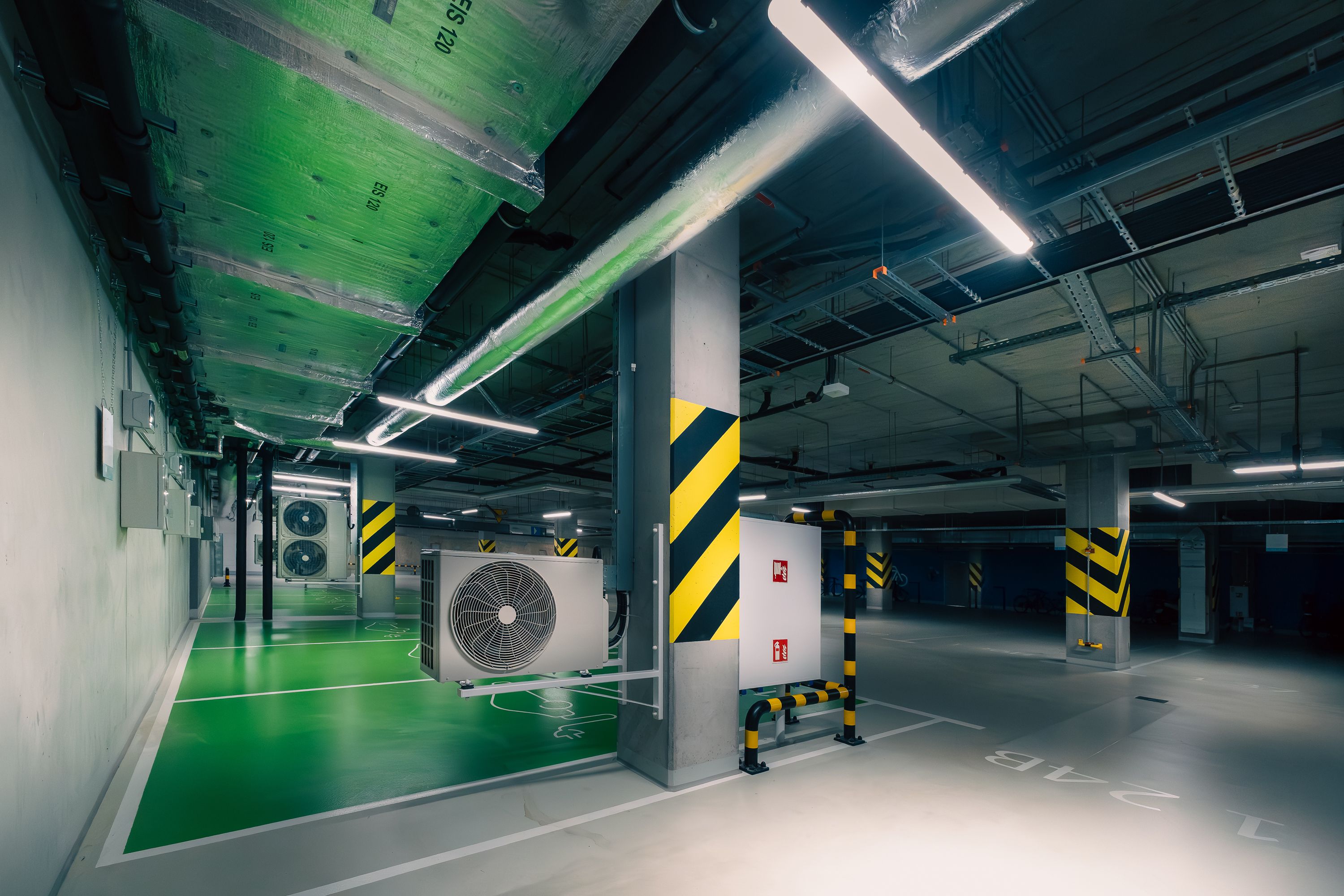 gratis Strakke ondergrondse parkeergarage met airconditioning en groene verlichting. Stockfoto