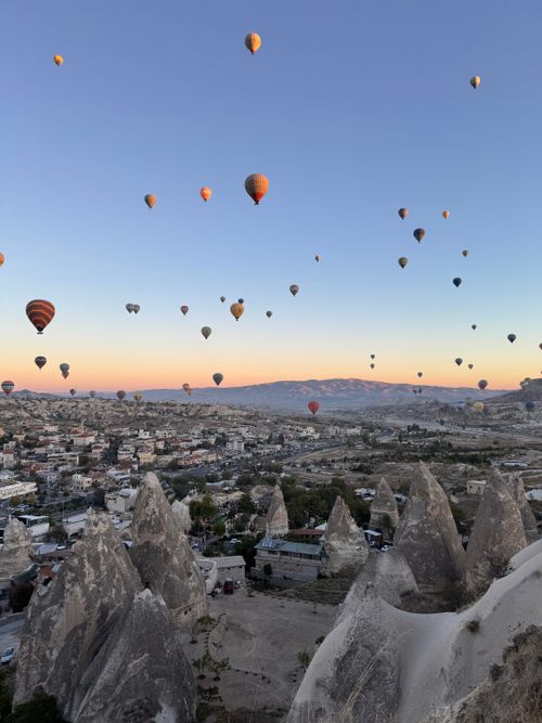 Free Hot air balloons soar above Cappadocia's unique rock formations at sunrise. Stock Photo