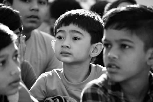 Engaged group of children in a thoughtful moment captured in black and white.