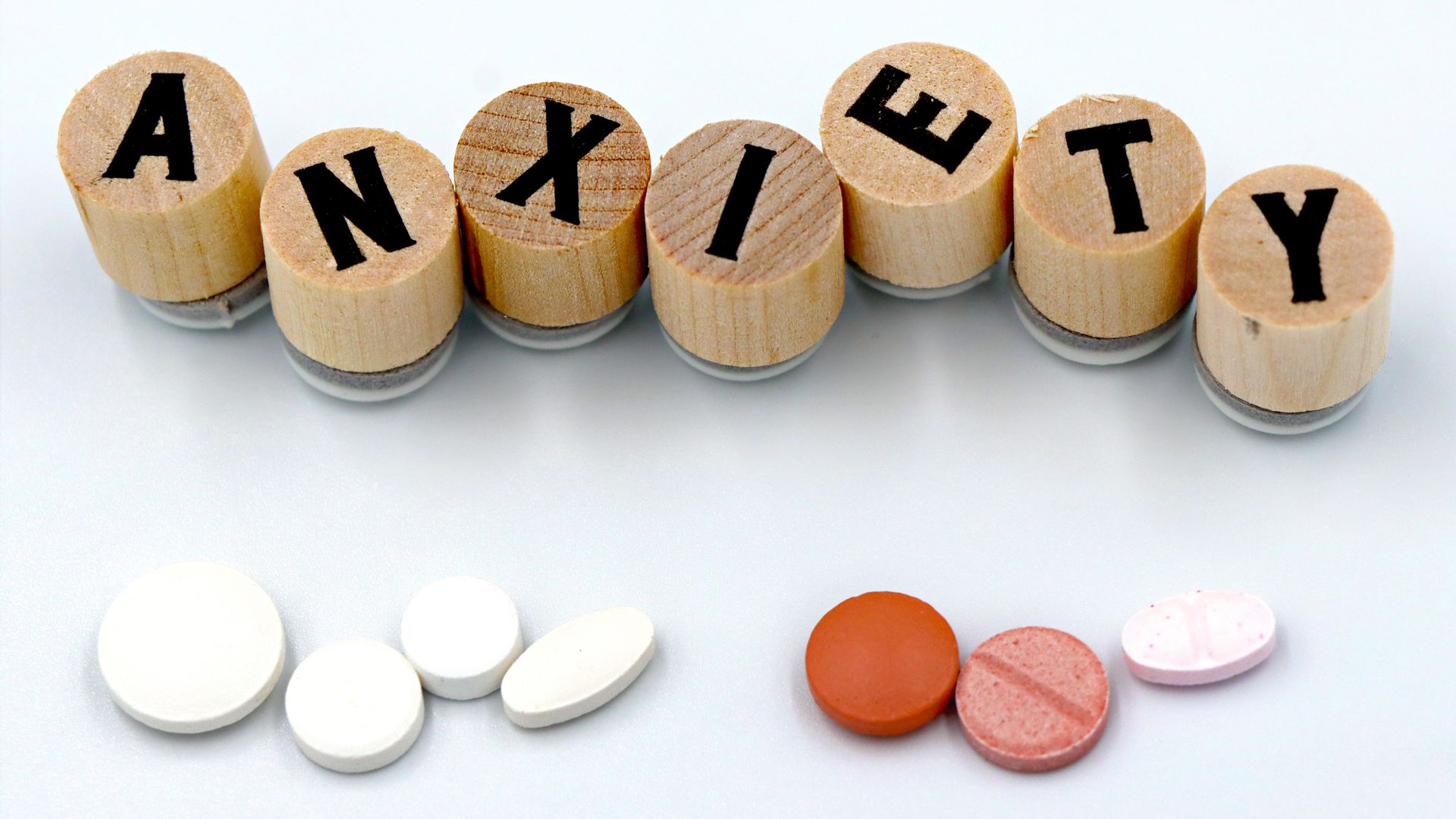 Can Modafinil Trigger Depression: Exploring the Link Wooden blocks spelling 'Anxiety' with assorted pills below on a light background — can modafinil trigger depression