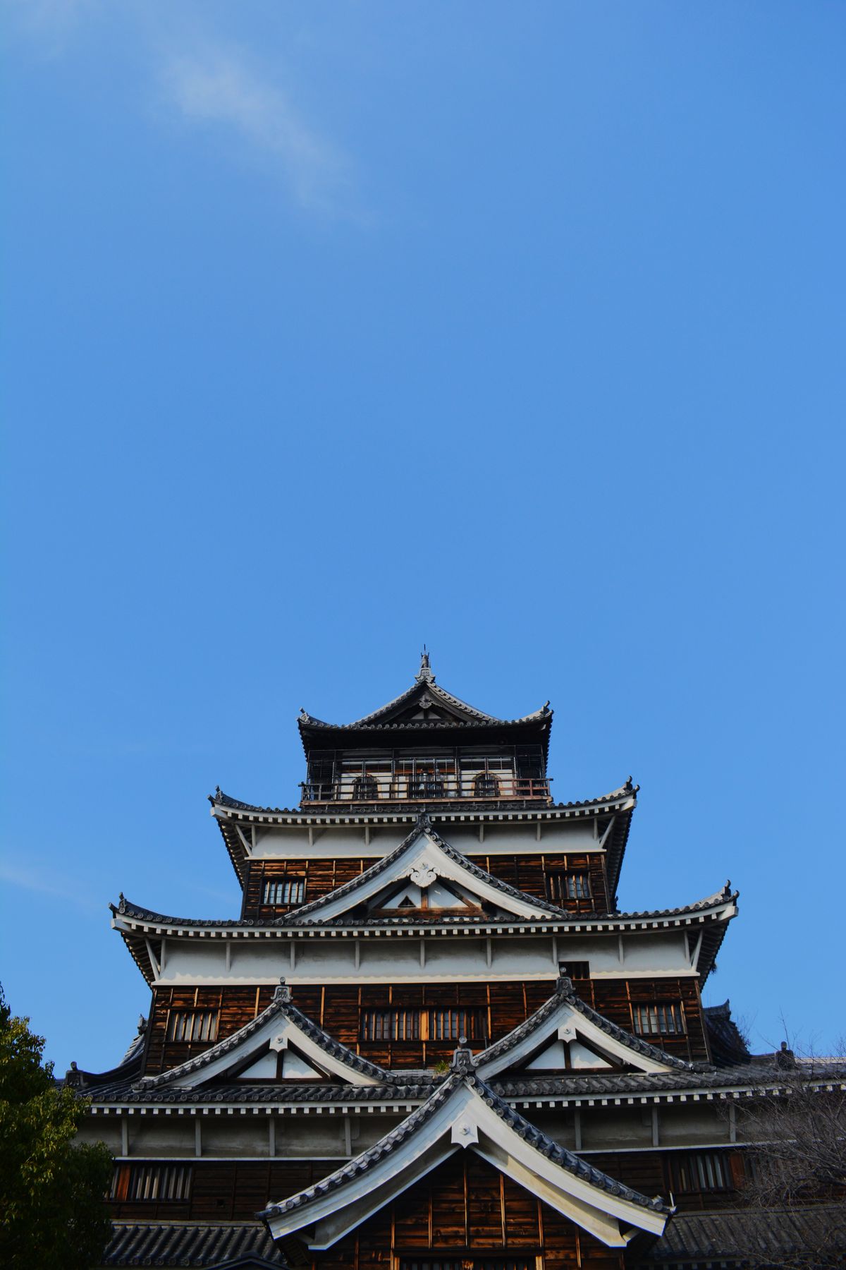 Hiroshima Castle under clear blue sky with iconic Japanese architectural details