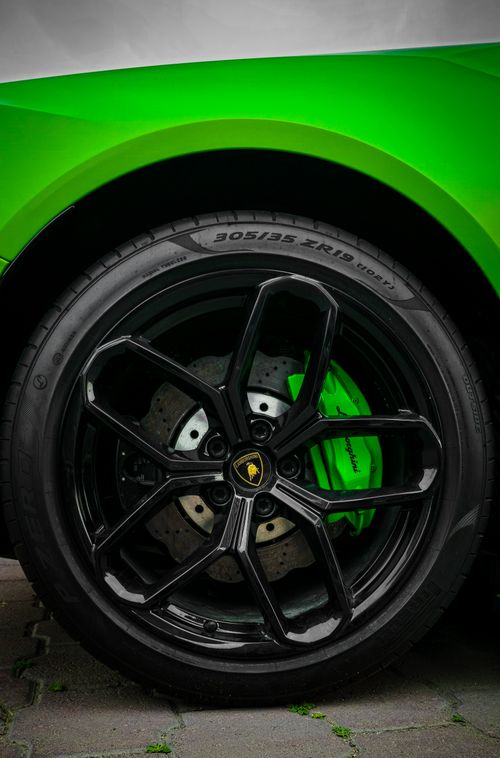Free Close-up of a vibrant green sports car wheel with black alloy rims. Stock Photo