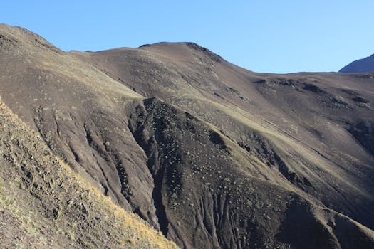 A stunning view of rugged brown mountains with a clear blue sky, perfect for nature enthusiasts.