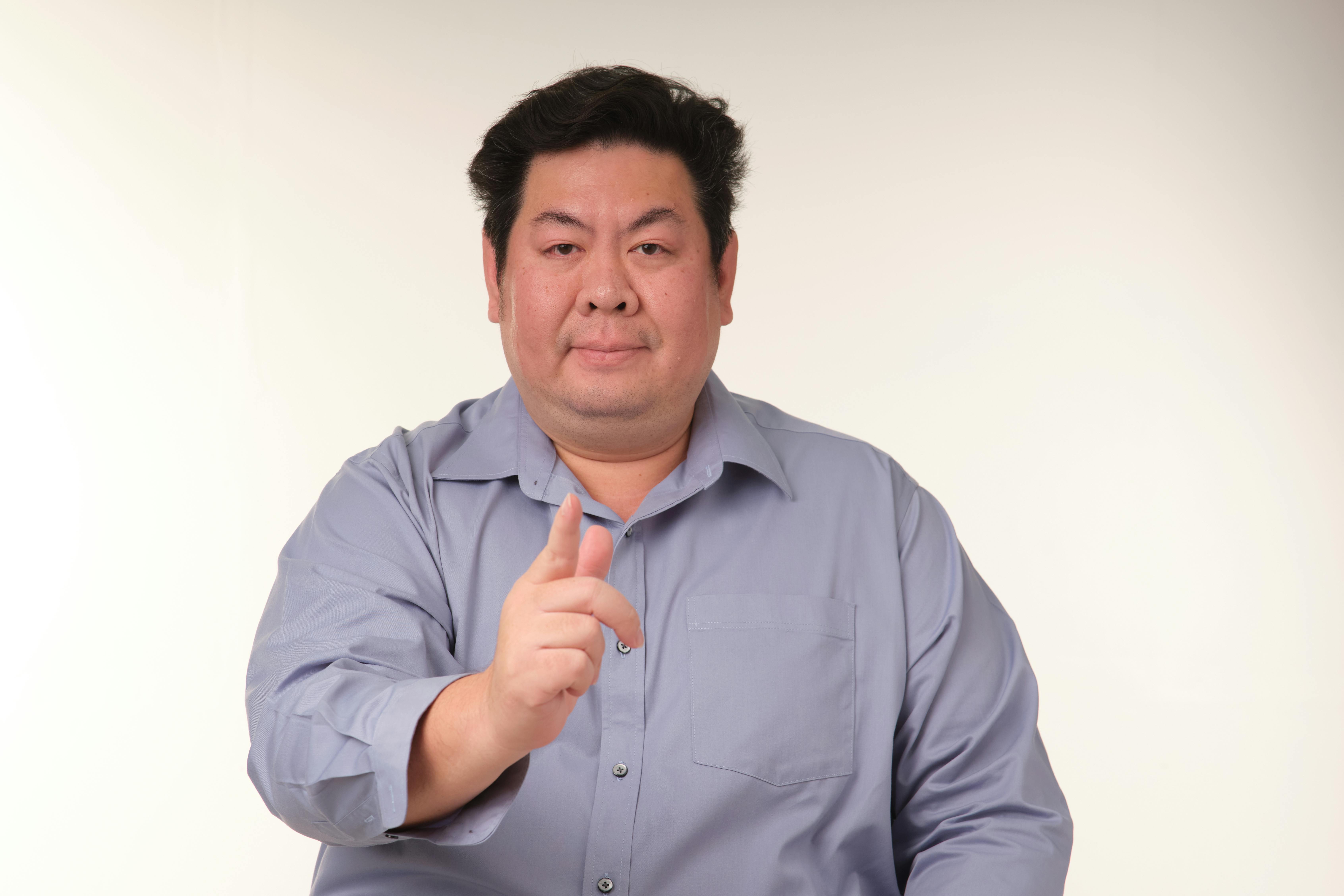 免費 一位身穿藍色襯衫的自信男子用手指做了一個手勢，強調了一點。 圖庫相片