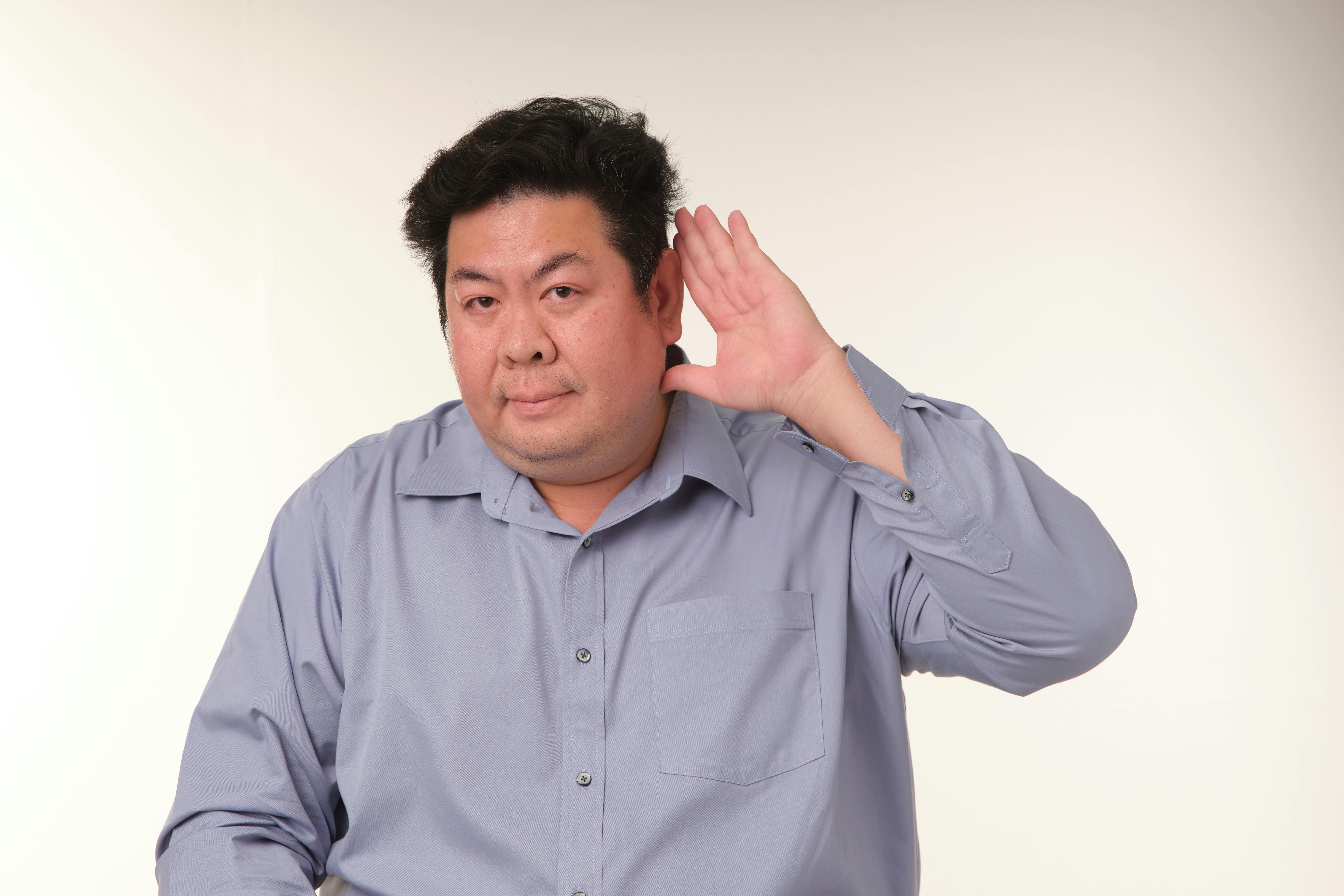 Miễn phí Một người đàn ông đang tạo dáng thể hiện cử chỉ lắng nghe trong phòng thu. Ảnh lưu trữ