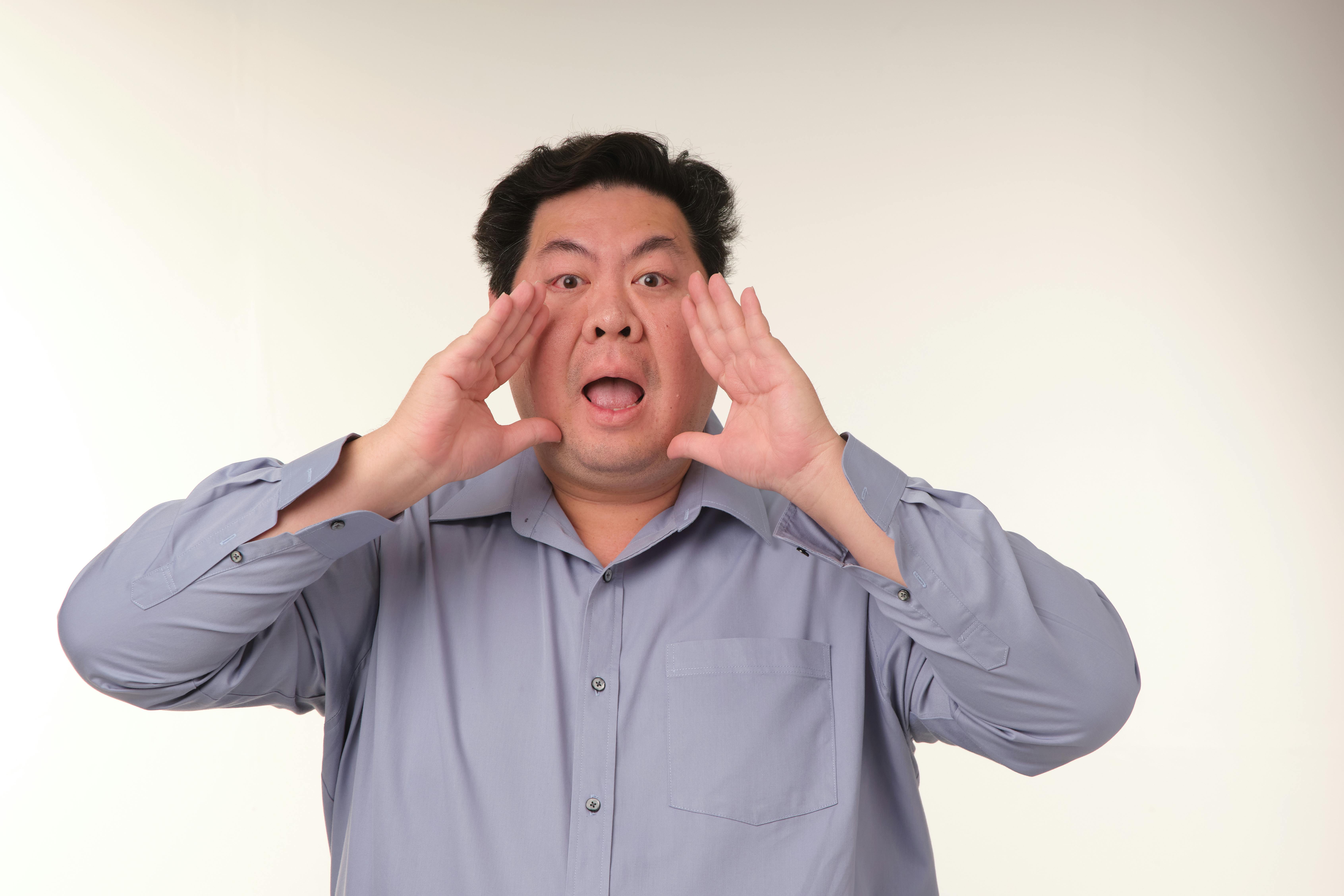 Miễn phí Người đàn ông trung niên hét lớn với hai tay đưa gần miệng, đang ở trong nhà. Ảnh lưu trữ