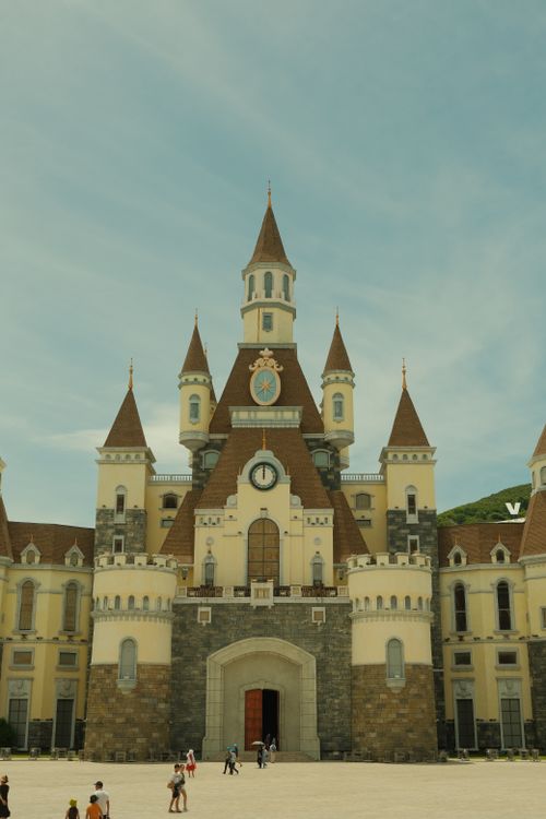 Free Majestic fairytale-like castle with pointed towers under a clear blue sky. Stock Photo
