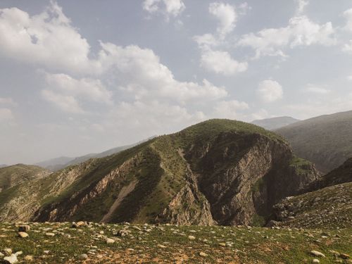 Free Scenic view of a lush green mountain range under a partly cloudy sky. Stock Photo