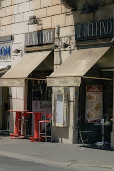 Outdoor view of an Italian cafe with vintage awnings on a sunny day.