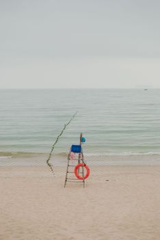 Serene beach scene featuring an empty lifeguard stand and calm sea view.