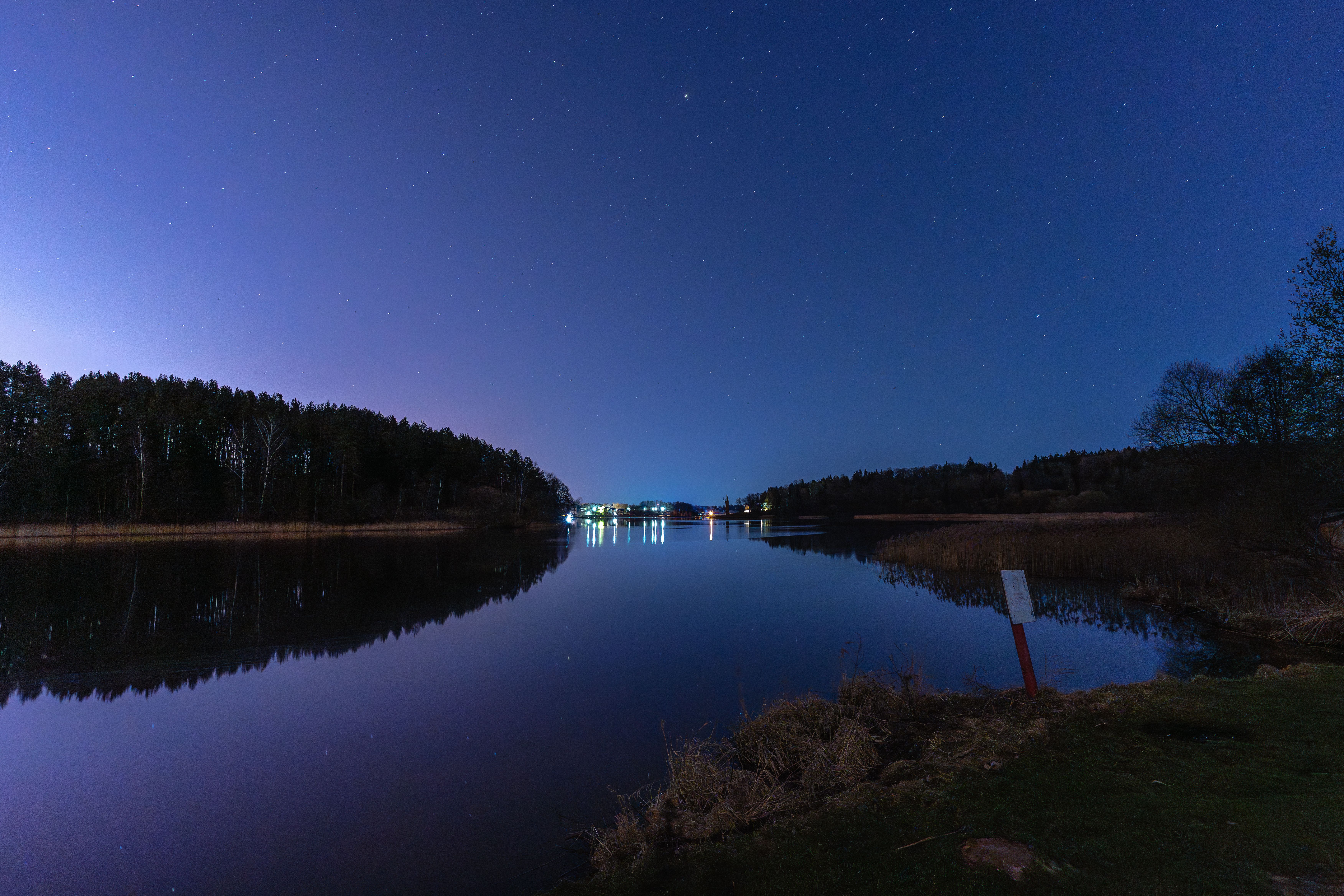 Tältläger vid sjö under kvällshimmel