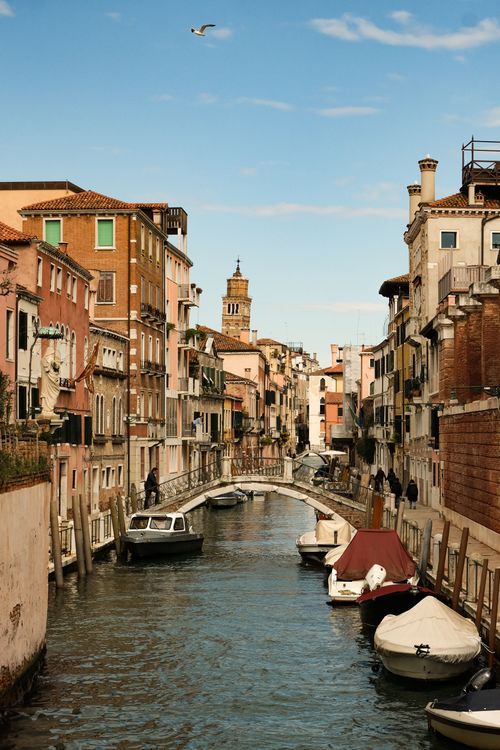 Free Charming canal scene in Venice with colorful buildings and small boats on a sunny day. Stock Photo