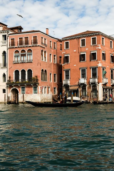 Scenic view of a vibrant Venetian canal lined with historic buildings and a traditional gondola.