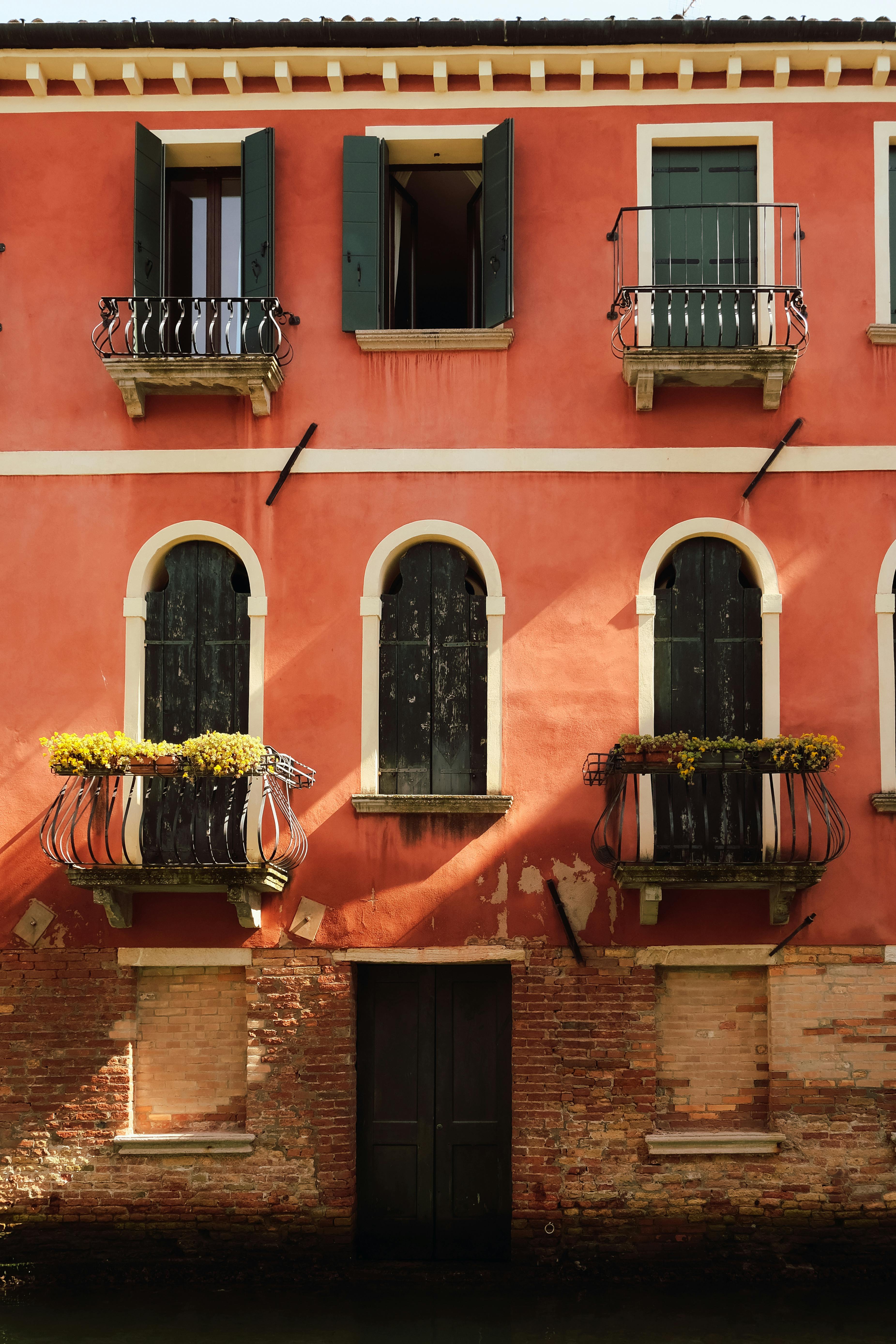 Vibrant Venetian building facade with classic arches and balconies over a canal.