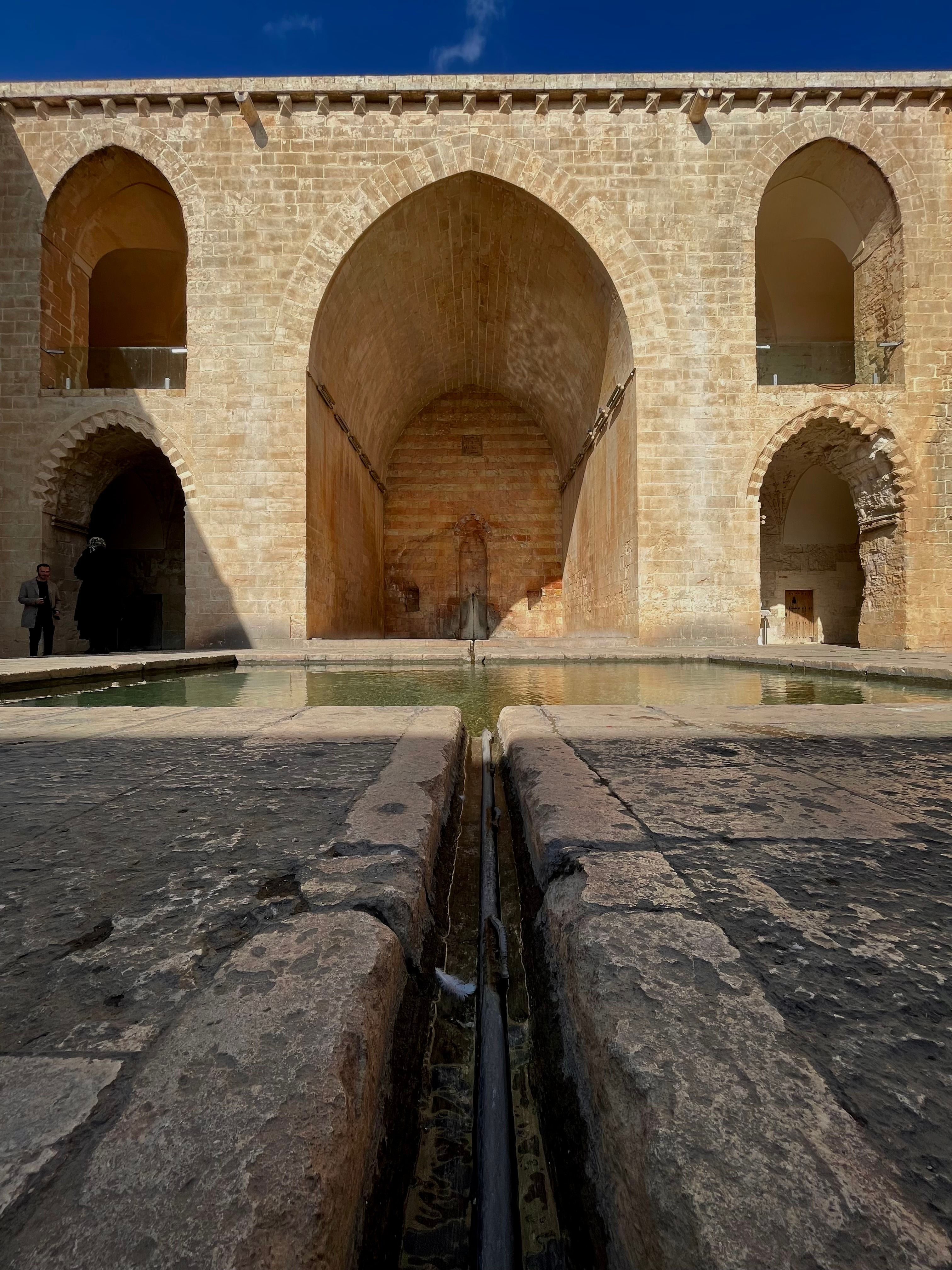 Explore the stunning historic architecture of Zinciriye Medrese in Mardin, Turkey, showcasing ancient stonework and archways.