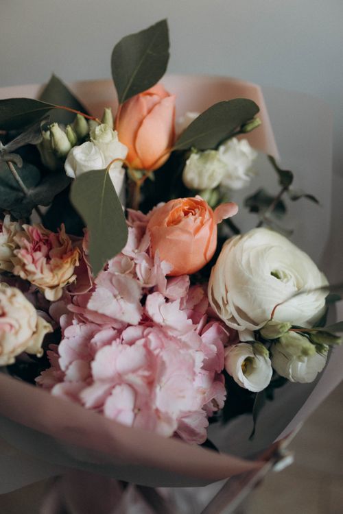 Free A delicate bouquet featuring pink hydrangeas, peach roses, and white ranunculus, perfect for weddings or celebrations. Stock Photo