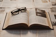 Vintage Open Book with Glasses on Antique Papers