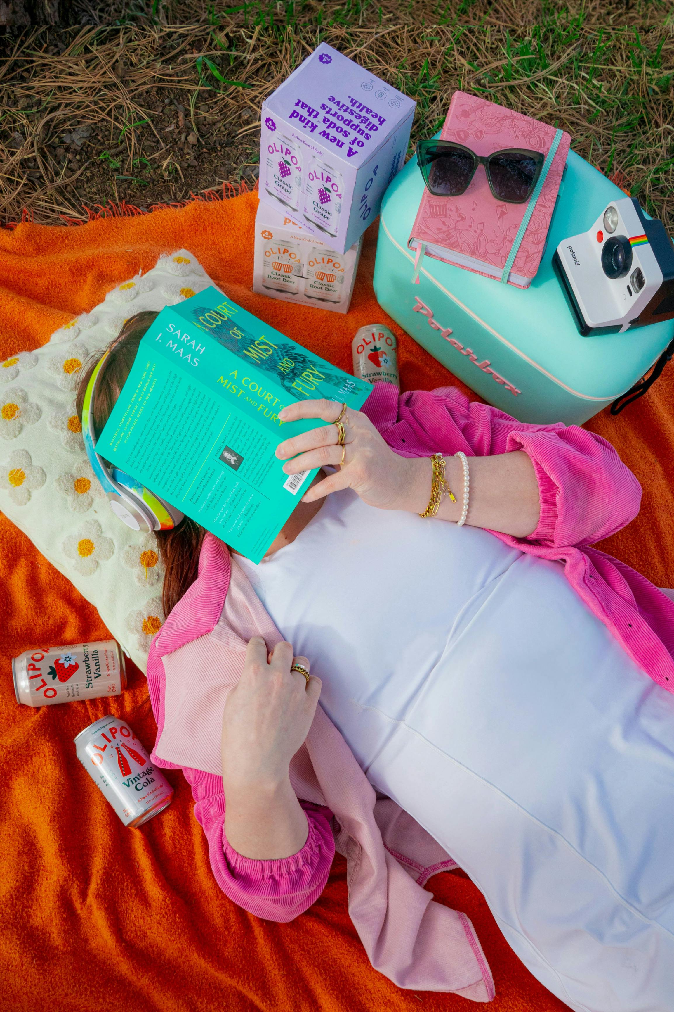 A vibrant picnic setup with a person enjoying a sunny day, surrounded by colorful items.