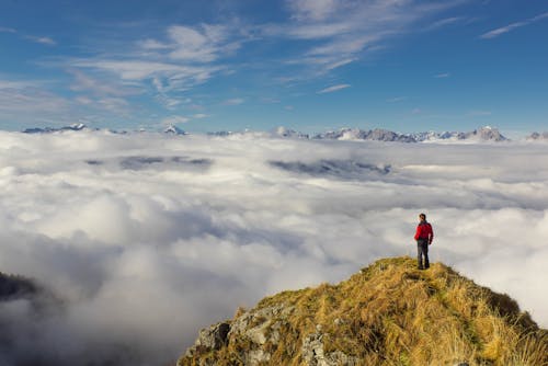 Free Man Standing on Mountain Against Sky Stock Photo