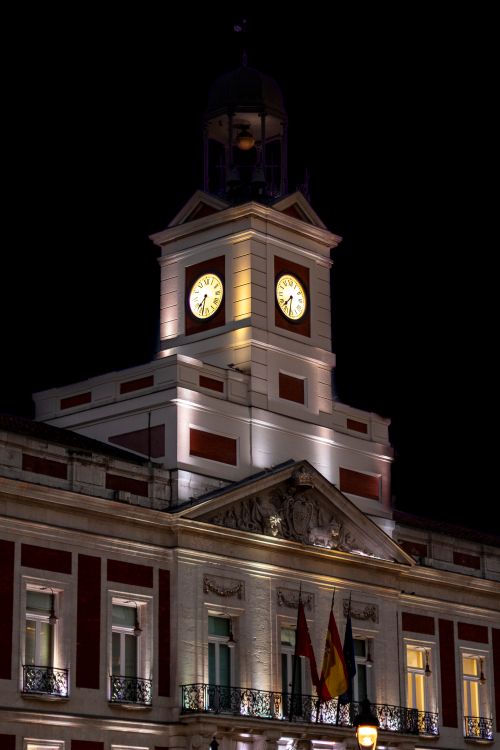 Free Illuminated clock tower at Puerta del Sol, Madrid, captured at night. Stock Photo