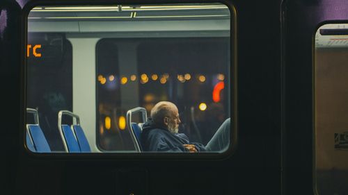 Free Senior man in a Houston metro train during nighttime, reflecting solitude and introspection. Stock Photo