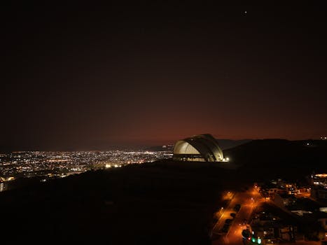 Captivating nighttime skyline of Guadalajara with illuminated buildings and a modern dome structure.