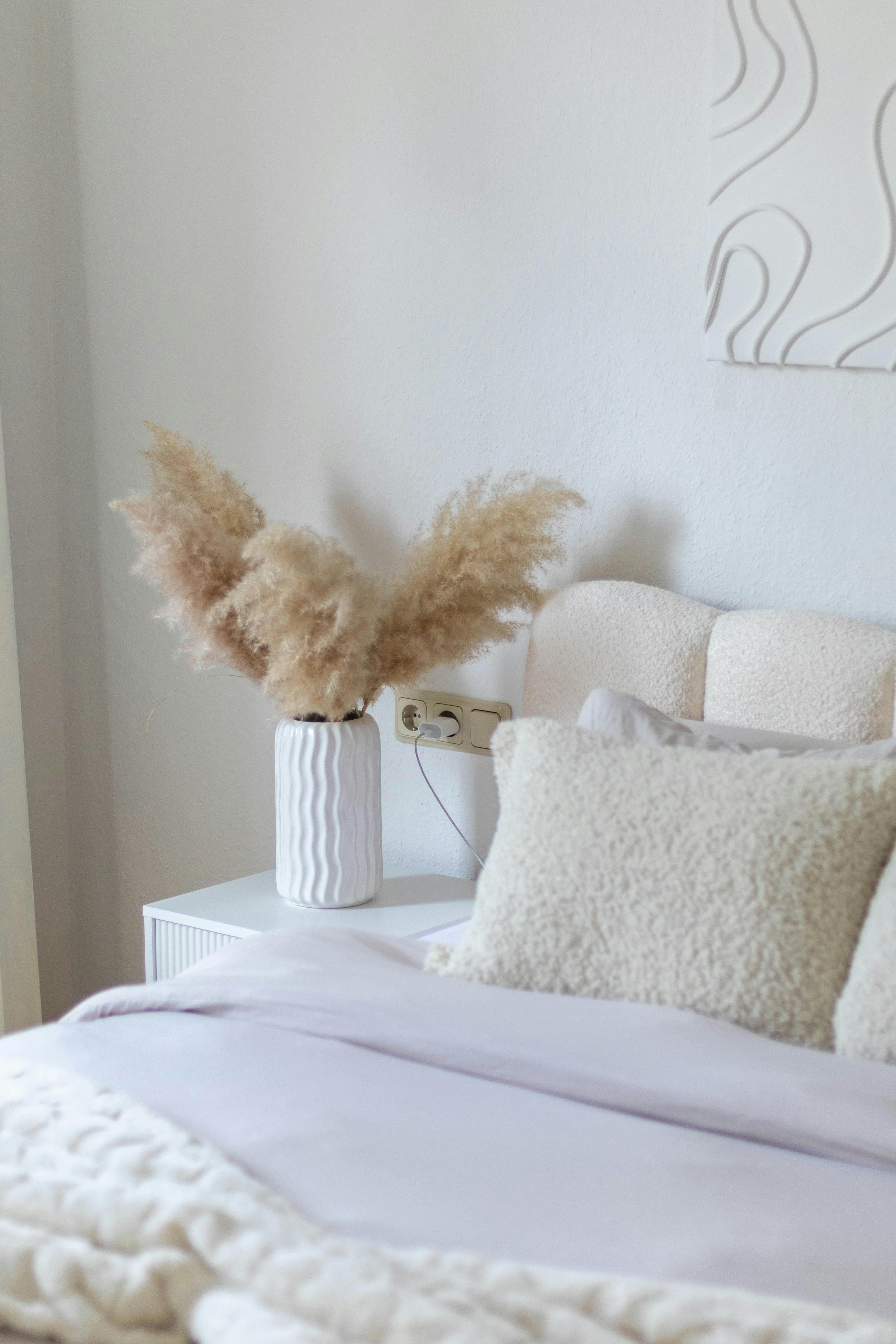 Bright and cozy modern minimalist bedroom featuring pampas grass and soft textures.
