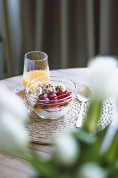 Delicious smoothie bowl with berries and nuts, served with a glass of fresh orange juice, perfect for a healthy breakfast.
