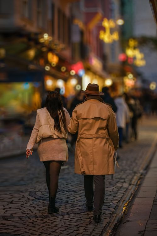 Free Couple strolling through a lively street at night, showcasing vibrant city life and urban atmosphere. Stock Photo