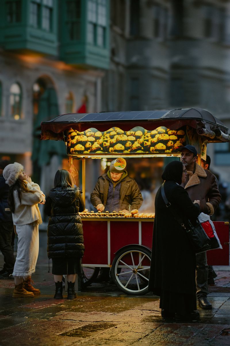 Street vendor selling food at a bustling night market with soft urban lighting.