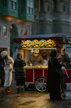Street vendor selling food at a bustling night market with soft urban lighting.
