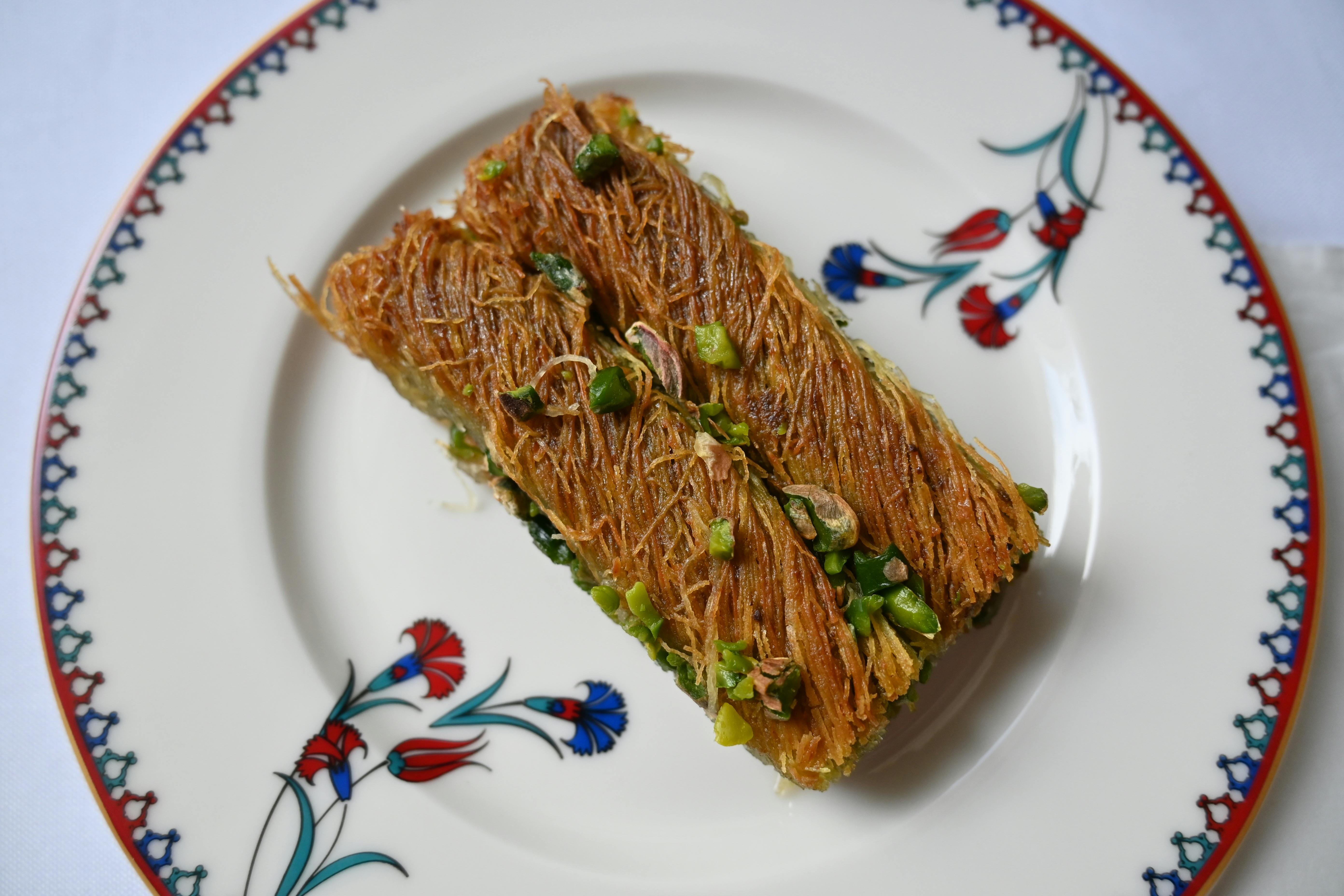 close-up shot of a Dubai chocolate bar being sliced, revealing pistachio cream and crispy kataifi layers
