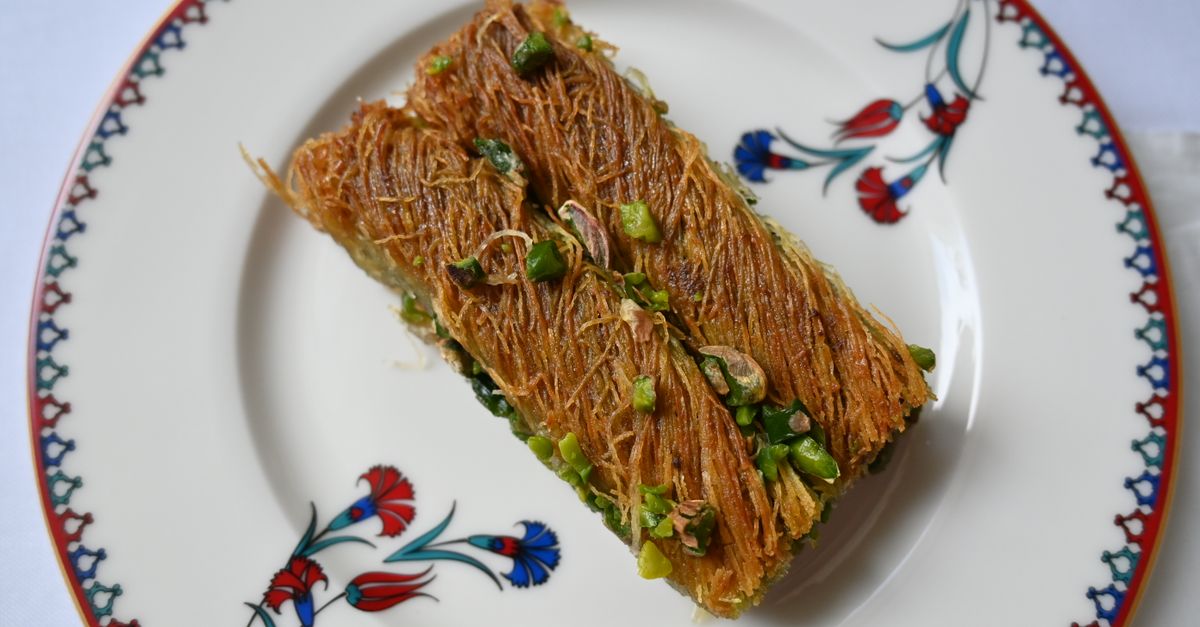 close-up shot of a Dubai chocolate bar being sliced, revealing pistachio cream and crispy kataifi layers