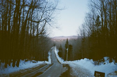 Free A serene winter road scene in Bethel, Maine, with snow and mountains. Stock Photo