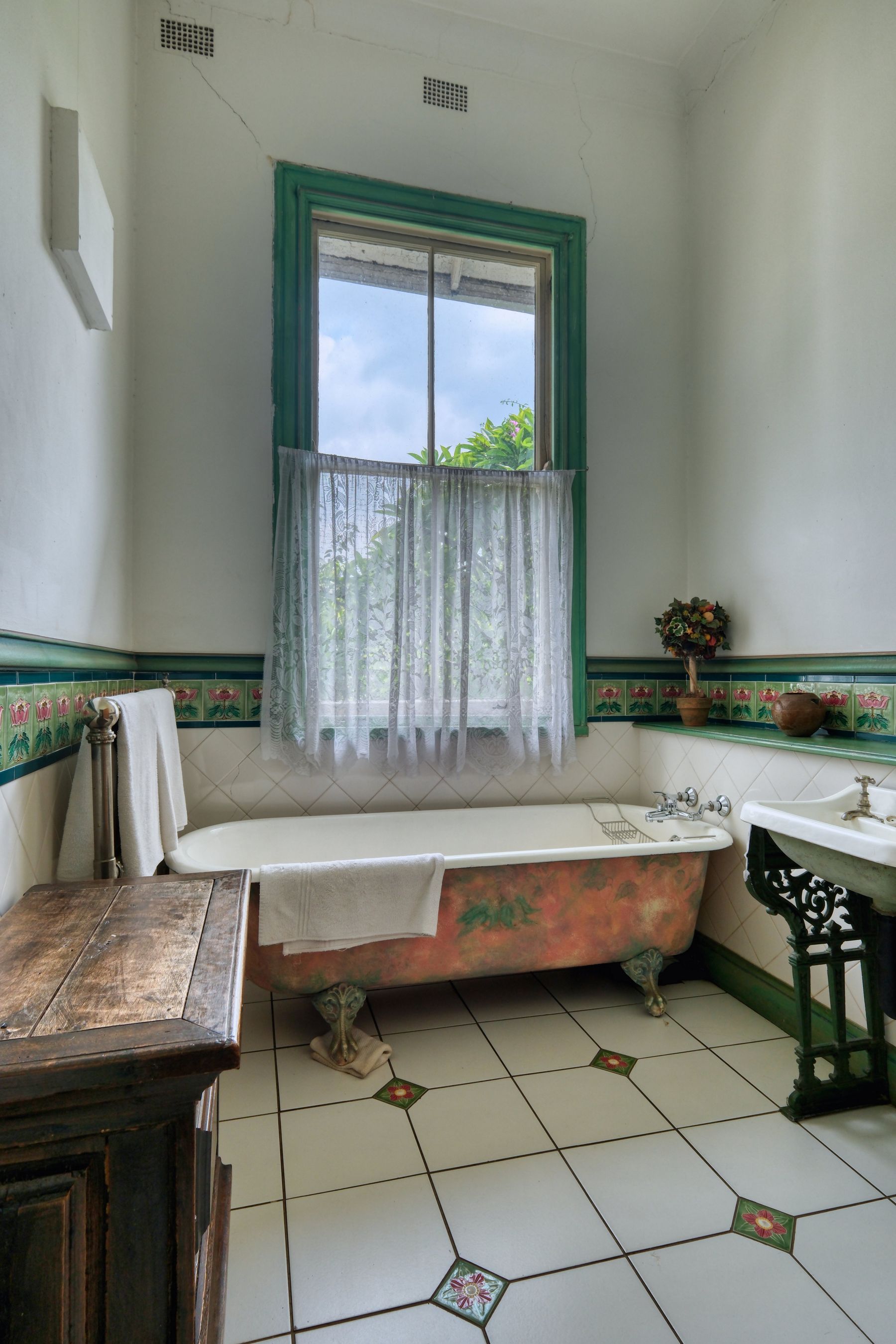 Victorian-inspired bathroom with clawfoot tub, floral detail and classic period character