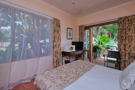 Inviting bedroom interior with garden view, large window, and soothing decor. Perfect for relaxation.