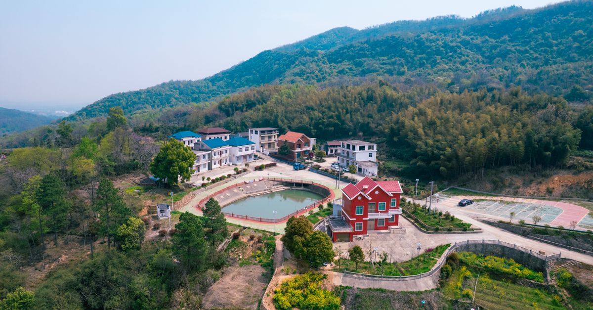 Aerial view of Ho township with green hills and community gathering spots
